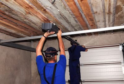 Contractors installing garage door opener. Repair garage door opener system.